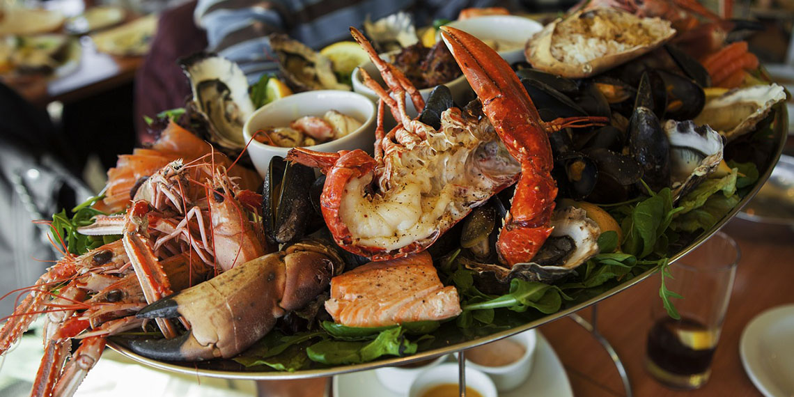 Cuál es el origen de comer mariscos en la playa